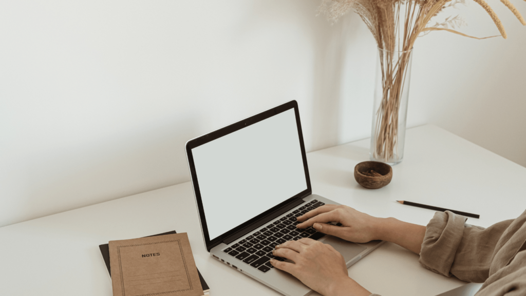 Woman typing on laptop at desk. Virtual wedding industry assistant